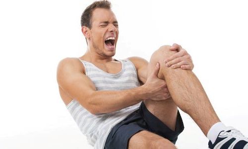 фото спортсмена держащегося за больное колено